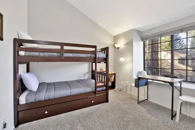 a bedroom with two bunk beds and a desk at Restmoore Big Bear~ Lakeside Condo Retreat~ in Big Bear Lake