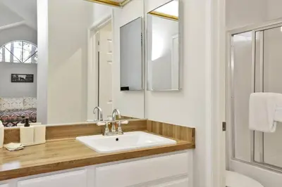 a white bathroom with a sink and a mirror at Restmoore Big Bear~ Lakeside Condo Retreat~ in Big Bear Lake