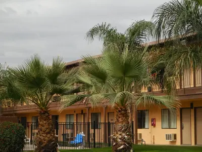 two palm trees in front of a building at Best Economy Inn & Suites in Bakersfield