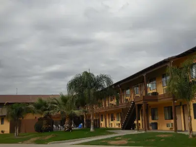 a building with palm trees in front of it at Best Economy Inn & Suites in Bakersfield