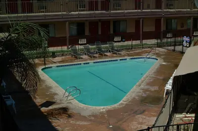 an empty swimming pool in front of a building at Best Economy Inn & Suites in Bakersfield