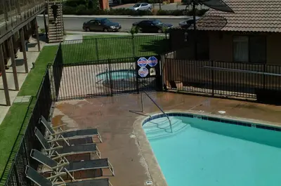 an empty swimming pool with chairs next to a building at Best Economy Inn & Suites in Bakersfield