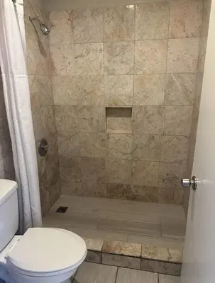 a bathroom with a shower with a toilet at Best Economy Inn & Suites in Bakersfield