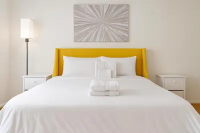 a bedroom with a white bed with a yellow headboard at Adorable and Bright 2BD 2BR 740 in Los Angeles