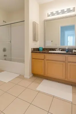 a bathroom with a tub and a sink and a mirror at Adorable and Bright 2BD 2BR 740 in Los Angeles