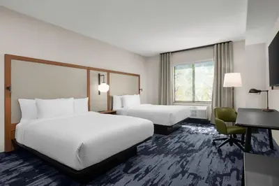 a hotel room with two beds and a desk at Fairfield by Marriott Inn & Suites Victorville in Victorville