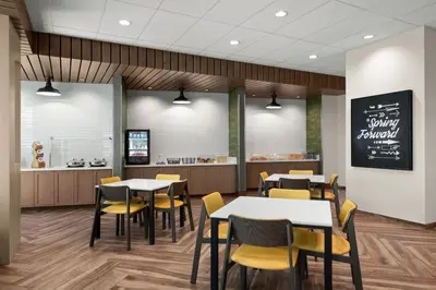 a dining room with tables and chairs and a counter at Fairfield by Marriott Inn & Suites Victorville in Victorville