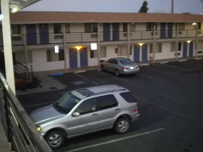 two cars parked in a parking lot in front of a building at Wasco Inn in Wasco