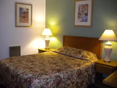 a hotel room with a bed and two lamps at Wasco Inn in Wasco