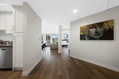 a kitchen and living room with a painting on the wall at The Turquoise Lounge - Chic 2BR Beach view Pool, Sauna in Los Angeles