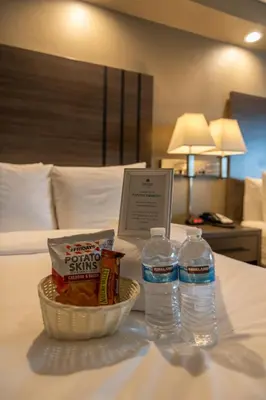 a tray of food and two water bottles on a bed at GreenTree Inn & Suites Los Angeles - Alhambra - Pasadena in Alhambra