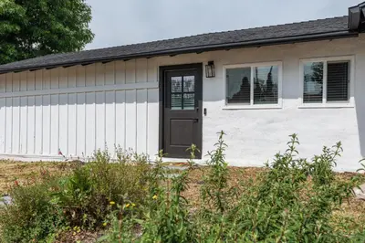 a small white house with a black door at Private Studio Oasis with Nature at Your Doorstep in Thousand Oaks