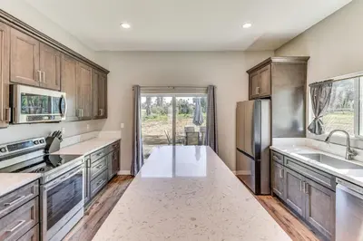 a kitchen with wooden cabinets and a stainless steel refrigerator at Peaceful Riverside Home with Patio, 7 Mi to Downtown in Riverside