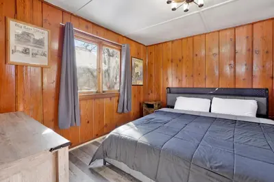 a bedroom with a bed in a wooden wall at Sunset Cottage Lakeside Couple's Cabin by Big Bear Vacations in Big Bear Lake