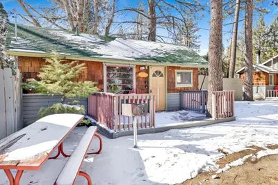 a house with a fence in the snow at Sunset Cottage Lakeside Couple's Cabin by Big Bear Vacations in Big Bear Lake