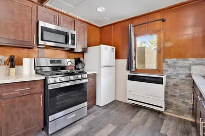 a kitchen with stainless steel appliances and wooden cabinets at Sunset Cottage Lakeside Couple's Cabin by Big Bear Vacations in Big Bear Lake
