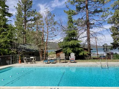 a swimming pool with two chairs and a house at Sunset Cottage Lakeside Couple's Cabin by Big Bear Vacations in Big Bear Lake