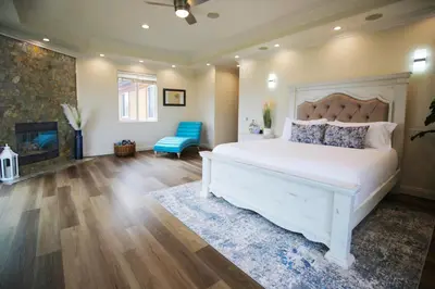 a bedroom with a white bed and a fireplace at 5 BR/5 BA Getaway with a View in Thousand Oaks