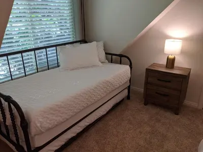 a bedroom with a bed and a nightstand with a window at “The Grey Haven” – Secluded home in the woods in Lake Arrowhead