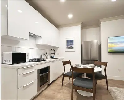 a kitchen with white cabinets and a table with chairs at New York Style 1bed 1bath West Hollywood in Los Angeles