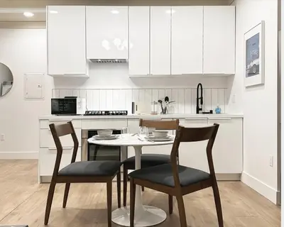 a kitchen with white cabinets and a table and chairs at New York Style 1bed 1bath West Hollywood in Los Angeles