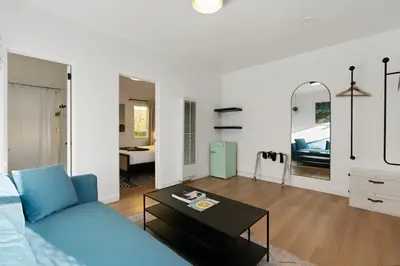 a living room with a blue couch and a table at Aliza Hotel in Los Angeles