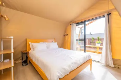 a bedroom with a bed and a large window at Glamping in the Urban in Glendora