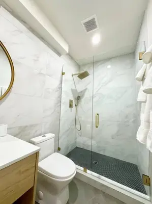 a white bathroom with a shower and a toilet at SummerLillie #1 in Summerland