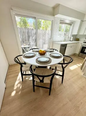 a kitchen with a table with four chairs and a table with fruit on it at SummerLillie #1 in Summerland