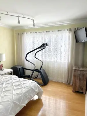a bedroom with a bed and a chair next to a window at CASA LUX MONICA Prime Santa Monica Luxury Home ONE-OF-A-KIND in Los Angeles