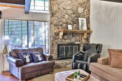 a living room with couches and a stone fireplace at Spa Steps to Lift Private Spa BBQ Massage Chair in Big Bear Lake