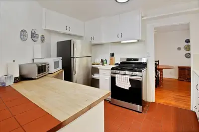 a kitchen with white cabinets and a stainless steel refrigerator at Hollywood-Sign Griffith-Observatory & Park Kng Bed in Los Angeles