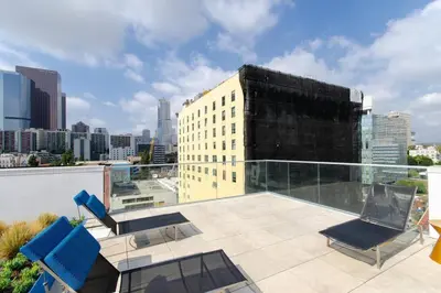 a balcony with two chairs and a building at Cozy 3bed Condo with balcony and a rooftop pool in Los Angeles