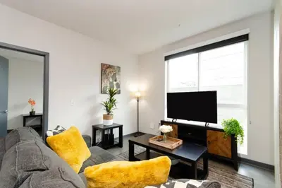 a living room with a couch and a flat screen tv at Cozy 3bed Condo with balcony and a rooftop pool in Los Angeles