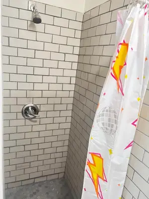 a shower curtain with a superhero design on it in a bathroom at LittleBetty's LandingPad in Torrance