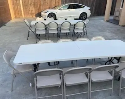 a white table and chairs with a white car behind it at Big & Cozy Duplex Home in Los Angeles