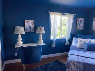 a blue bedroom with a bed and a window at Big & Cozy Duplex Home in Los Angeles