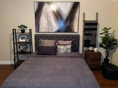 a bedroom with a bed with pillows and a painting at Big & Cozy Duplex Home in Los Angeles