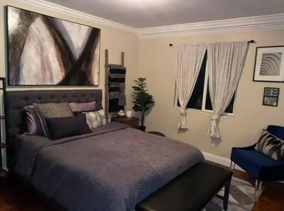 a bedroom with a bed and a blue chair at Big & Cozy Duplex Home in Los Angeles
