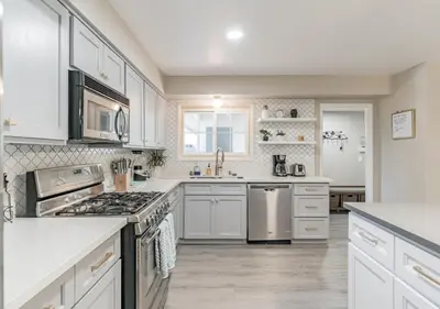 a kitchen with white cabinets and a stove top oven at Charming pet friendly family getaway Santa Clarita in Santa Clarita