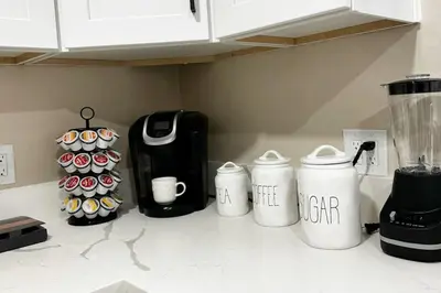a kitchen counter with four white coffee pots and cupcakes at Modern Home Near Ontario Airport in Ontario