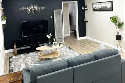 a living room with a blue couch and a tv at Modern Home Near Ontario Airport in Ontario