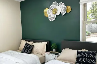 a bedroom with two beds and a flower clock on the wall at Modern Home Near Ontario Airport in Ontario