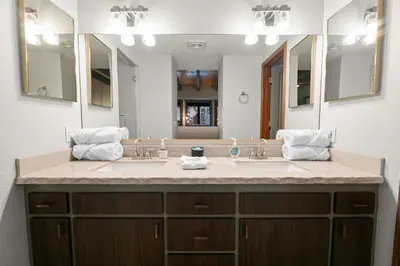a bathroom with two sinks and a large mirror at Evergreen -LUXURY CABIN WITH A HOT TUB, GAME ROOM & 3 EN-SUITE BEDROOMS! in Big Bear Lake
