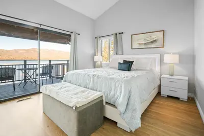 a white bedroom with a bed and a balcony at Lakehouse Retreat - Community Pool, Lake Views and Walk to Village! in Big Bear Lake