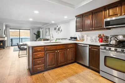a kitchen with wooden cabinets and stainless steel appliances at Lakehouse Retreat - Community Pool, Lake Views and Walk to Village! in Big Bear Lake