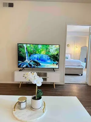 a living room with a flat screen tv and a flower at Luxe Marina Del Rey Apartment,Parking, Gym, Pool, jacuzzi,BBQ in Los Angeles