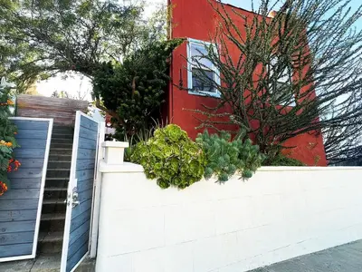 a retaining wall with plants in front of a red building at Modern, Remodeled Echo Park House-Walk to Sunset Blvd, Dodgers Stadium, Shops, Bars, Restaurants, Lake, Concerts in Los Angeles