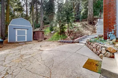 a house with a blue shed next to a driveway at Idyllic Cabin in the Woods Cozy Crestline Retreat in Arrowhead Highlands