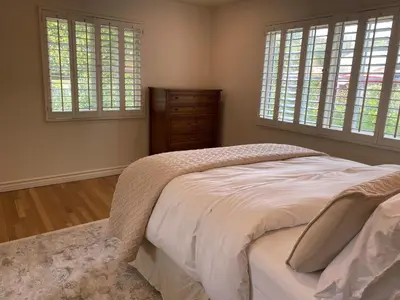 a bedroom with a bed and two windows and a dresser at Guest house with private entry and large pool in Los Angeles